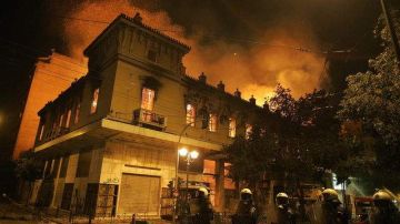 Las llamas invaden el edificio del cine Attikon durante las protestas, ayer, en el centro de Atenas.