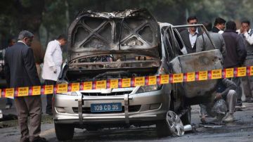 Unos miembros de las fuerzas de seguridad y forenses de la policía examinan un coche de la Embajada israelí en la India después de un atentado en Nueva Delhi.