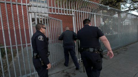 Agentes policiacos entran a la preparatoria Fremont, donde el lunes fue arrestado un ayudante de maestro.