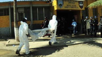 Empleados del servicio forense trasladan los cádaveres de las víctimas del incendio en la Granja Penal de Comayagua. Gustavo Amador