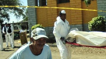 Empleados del servicio forense tasladan los cádaveres ocasionados por un incendio en la Granja Penal de Comayagua.