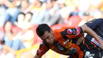 El delantero Christian Bermúdez (der.), de las Águilas, y Daniel Arreola, del Pachuca, se enfrascan en una lucha por el esférico.