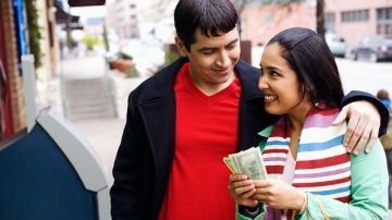 Una pareja cuenta el dinero recibido por un trabajo hecho en casa