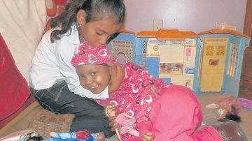 Yarelis Bonilla, 5, abrazada por su hermana Giselle, de siete años de edad.