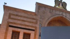 Un sirio muestra un cartel en el que se lee "Sí a la ciudadanía, no a la discriminación y al tercer artículo.