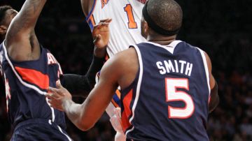 Amare Stoudemire, de los Knicks, se eleva hacia el canasto entre Marvin Williams (izq) y Josh Smith (der.) de los Hawks durante el partido de anoche en el Garden.