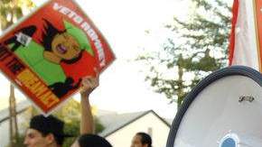 La presidente de la Coalición de Arizona por el Dream Act, Dulce Matuz, hablaba con sus seguidores a través del megáfono en una manifestación días atrás. En el fondo, la activista, Dolores Huerta.