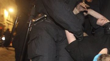 Agentes de policía detienen a un manifestante durante el desalojo del campamento 
de indignados frente a la catedral de San Pablo, en el este de Londres.