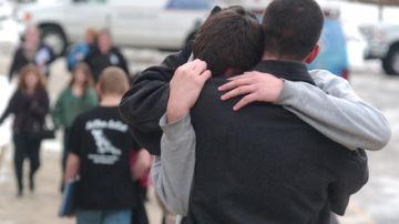 Un padre abraza a su hijo frente a la escuela   secundaria de Chardon, donde ocurrió  el tiroteo donde murieron 3 alumnos.