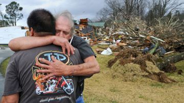 Dos víctimas se abrazan al evidenciar los estragos  que causaron los fenómenos meteorológicos en su paso por el estado de Alabama.