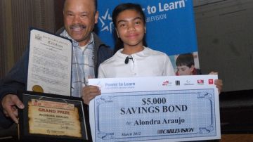 El orgulloso padre Rufino Araujo acompaña a su hija Alondra quien muestra su premio luego de participar con éxito en un concurso de ensayo literario.
