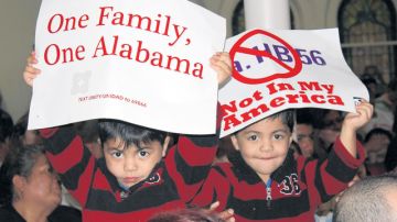 Dos niños sostienen unos carteles durante un mitín el  lunes 21 de noviembre de 2011, en Birmingham, Alabama,  para exigir la revocación de la ley HB56 que criminaliza a los inmigrantes indocumentados en Alabama.