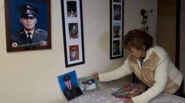 Virginia Franco, de 70 años, la madre del sargento Luis Alberto Beltrán, secuestrado por la guerrilla, coloca un retrato de su hijo.