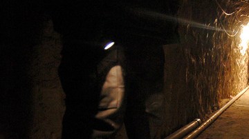 Un policía mexicano enciende  su linterna para mostrar el interior de este  túnel que tiene  3798 pies de largo   que pasa de México a EE.UU. por el sur de California.