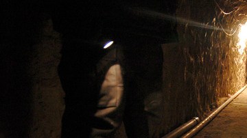 Un policía mexicano enciende  su linterna para mostrar el interior de este  túnel que tiene  3798 pies de largo   que pasa de México a EE.UU. por el sur de California.