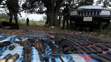 Soldados mexicanos muestran un fuerte decomiso de armas y cocaína en el estado de Veracruz.