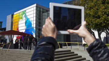 Una persona toma fotos con su iPad al logotipo de Apple impreso en el centro Yerba Buena en San Francisco, California donde ayer se vendieron cantidades.