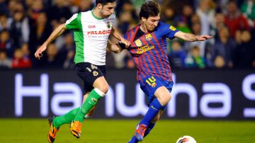 Ni jalándolo de la camiseta puede Álvaro González detener al ariete argentino, Lionel Messi, quien conduce el balón en el juego de ayer.