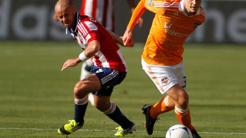 Andre Hainault, autor del gol del Dynamo, deja atrás a de Laurent Courtous, de Chivas USA, en el juego inaugural.