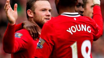 Wayne Rooney  (izq.) marcó los dos goles del   United ante West Bromwich Albion para retomar el liderato.