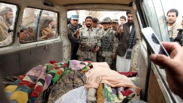 Personas muestran los cadáveres de afganos asesinados presuntamente por un soldado estadounidense, en la localidad de Panjwai.