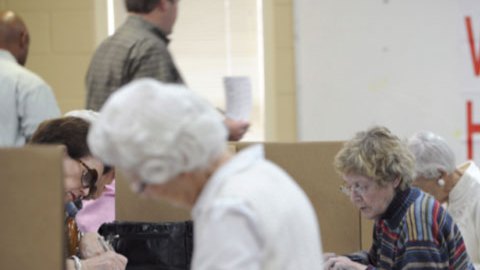 Ciudadadanos preparan sus papeletas antes de votar en las primarias, en Montgomery, Alabama.