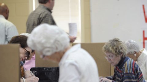 Ciudadadanos preparan sus papeletas antes de votar en las primarias, en Montgomery, Alabama.