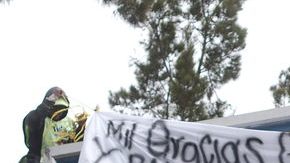 Trabajadores de la municipalidad de Ciudad Guatemala quitan una 'narcomanta', puesta por supuestos miembros  de Los Zetas, ayer.