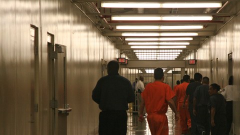 Reos inmigrantes caminan por el pasillo de un centro de detención en Lumpkin, Georgia.
