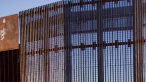 En la foto del 28 de enero de 2012, Agustín Portillo y su esposa Ana  caminan a lo largo de la valla que marca la frontera entre   Estados Unidos y México, en Tijuana.
