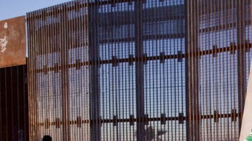 En la foto del 28 de enero de 2012, Agustín Portillo y su esposa Ana  caminan a lo largo de la valla que marca la frontera entre   Estados Unidos y México, en Tijuana.