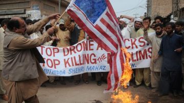 Varios manifestantes queman una bandera estadounidense mientras gritan consignas contra la masacre de 16 afganos a manos de un soldado de EEUU.