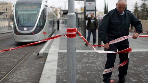 Un policía israelí acordona el lugar de un crimen en Jerusalén (lsrael) donde un palestino fue arrestado sospechoso de apuñalar a una soldado israelí.
