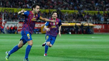 Xavi Hernández (izq), del Barcelona, celebra su gol al Sevilla ayer con su compañero Lionel Messi, quien se lució con otro tanto de antología.
