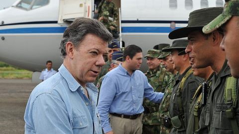 El presidente, Juan Manuel Santos (i), y su ministro de Defensa, Juan Carlos Pinzón (2-i) saludan a las autoridades militares y policías locales en Arauca.