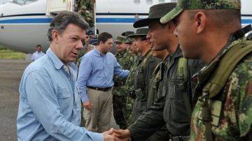 El presidente, Juan Manuel Santos (i), y su ministro de Defensa, Juan Carlos Pinzón (2-i) saludan a las autoridades militares y policías locales en Arauca.