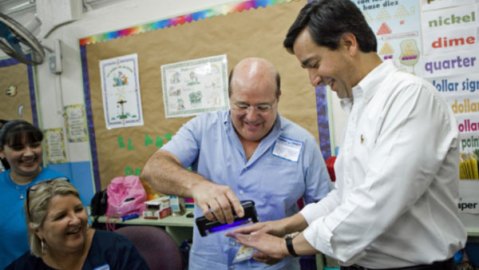 Un voluntario utiliza una luz para ver los dedos del Gobernador Fortuño (d), para confirmar que no ha votado anteriormente, el pasado 18 de marzo.