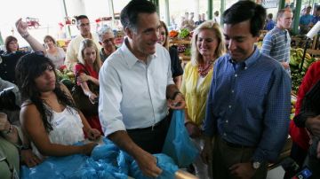 El republicano a la Presidencia de EEUU Mitt Romney (i) saluda a seguidores en la plaza del mercado en Bayamón, Puerto Rico.