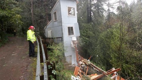Los bomberos Greg Martin y Tim Williams estudian cómo ayudar en esta situación: Los fuertes vientos y la lluvia provocaron que esta casa se partiera en dos en Camp Meeker, en el condado de Sonoma, en California.
