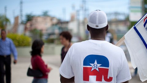 Un hombre hace campaña en Bayamón a favor del precandidato Mitt Romney.