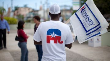 Un hombre hace campaña en Bayamón a favor del precandidato Mitt Romney.