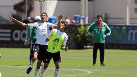 Diego Reyes conduce el balón ante la marca de Alan Pulido en la práctica de ayer del Tri en Carson.