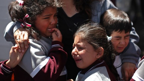 Una mujer consuela a niños que fueron evacuados en las afueras de una escuela en la colonia Roma, tras terremoto que se sintió ayer en la Ciudad de México.