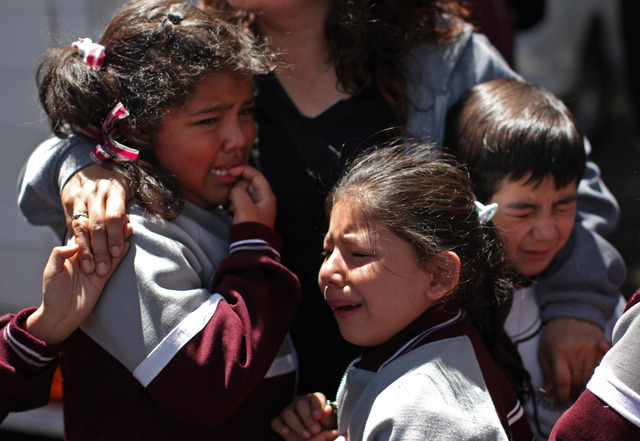 Una mujer consuela a  niños que fueron evacuados en las afueras  de una escuela en la colonia Roma, tras terremoto que se sintió ayer en la Ciudad de México.
