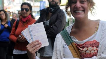 Una mujer muestra las entradas para el concierto del músico británico.