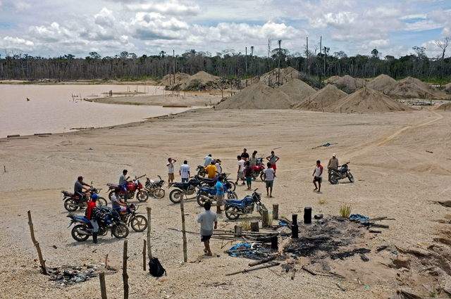 Comuneros de la cuenca del río Manuani recorren en motocicletas el sector denominado 'La Pampa'. Arriba, aspecto de los restos de un prostíbulo.