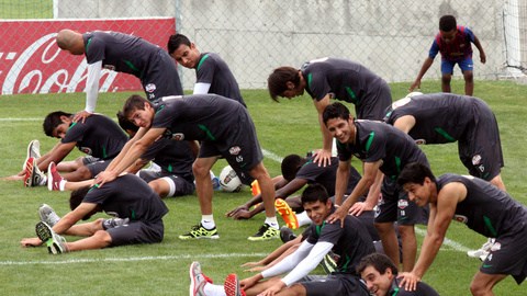 Jugadores del Monterrey realizan ejercicios de estiramiento durante  la práctica de ayer en la cancha de El Barrial.