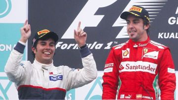 El piloto mexicano Sergio Pérez (izq.) celebra su segundo lugar en el Premio de Malasia junto al ganador, el español Fernando Alonso.