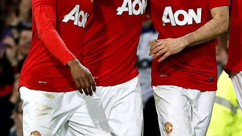 Wayne Rooney (cent.) es felicitado por  Patrice Evra (izq.) y Ryan Giggs.