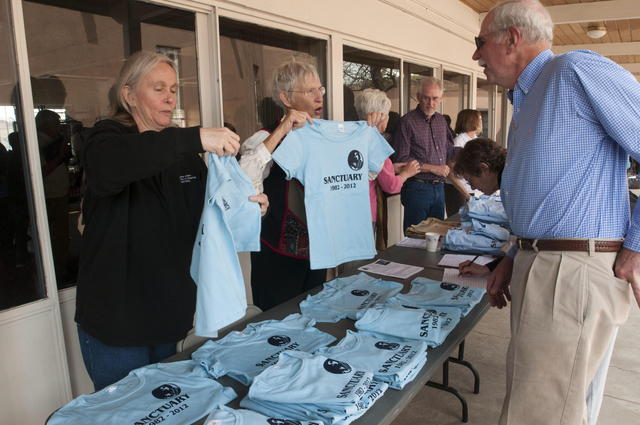 Voluntarias  venden camisetas conmemorativas del movimiento Santuario.